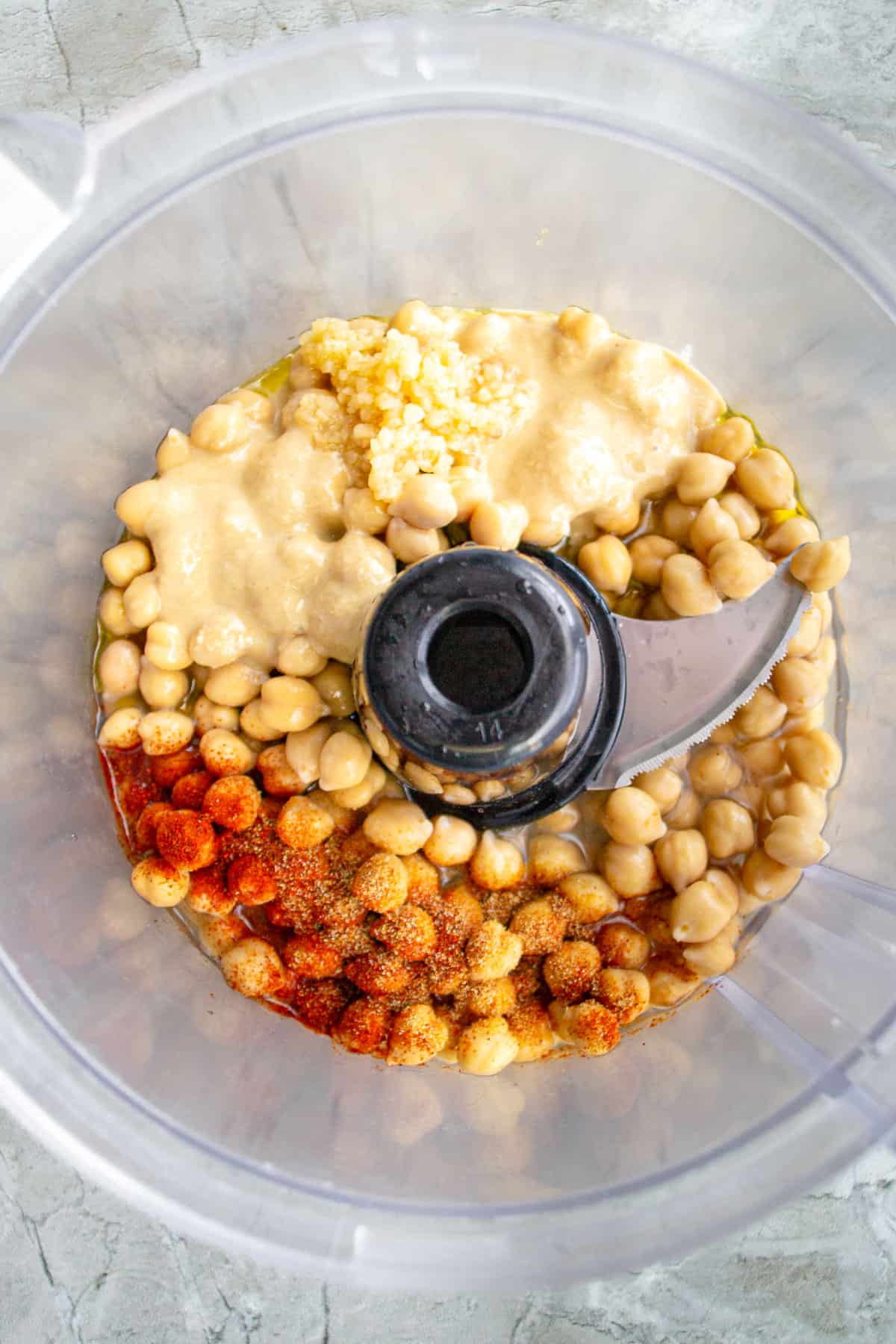 Ingredients for buffalo hummus in a food processor.