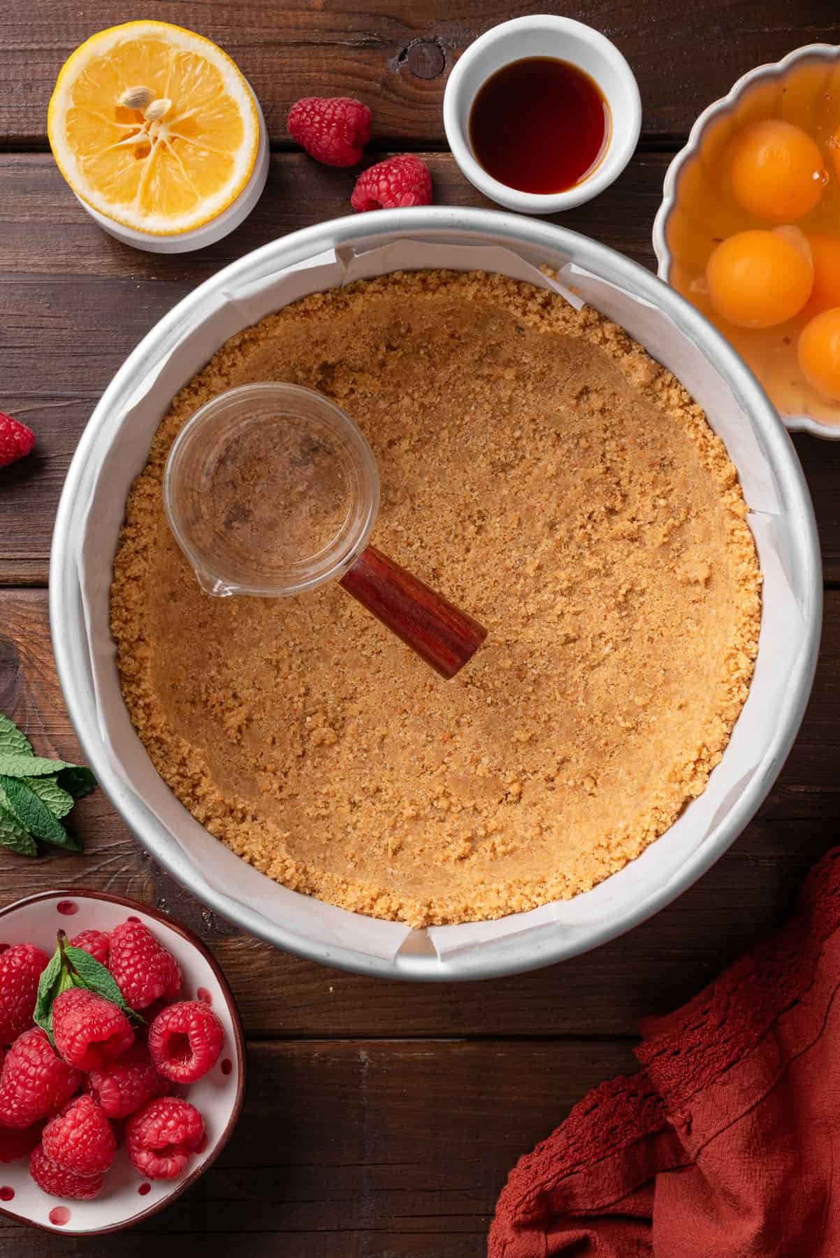Adding ground cracker crust to the baking pan.