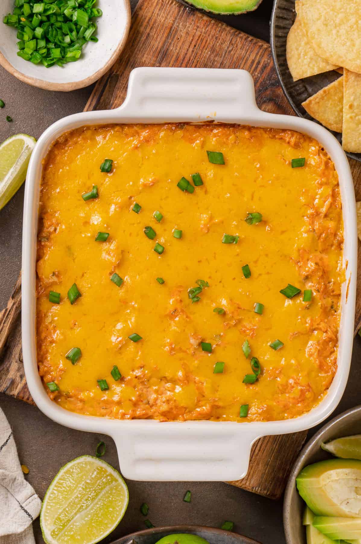baked buffalo chicken dip topped with melted Cheddar cheese on top - in a baking dish.