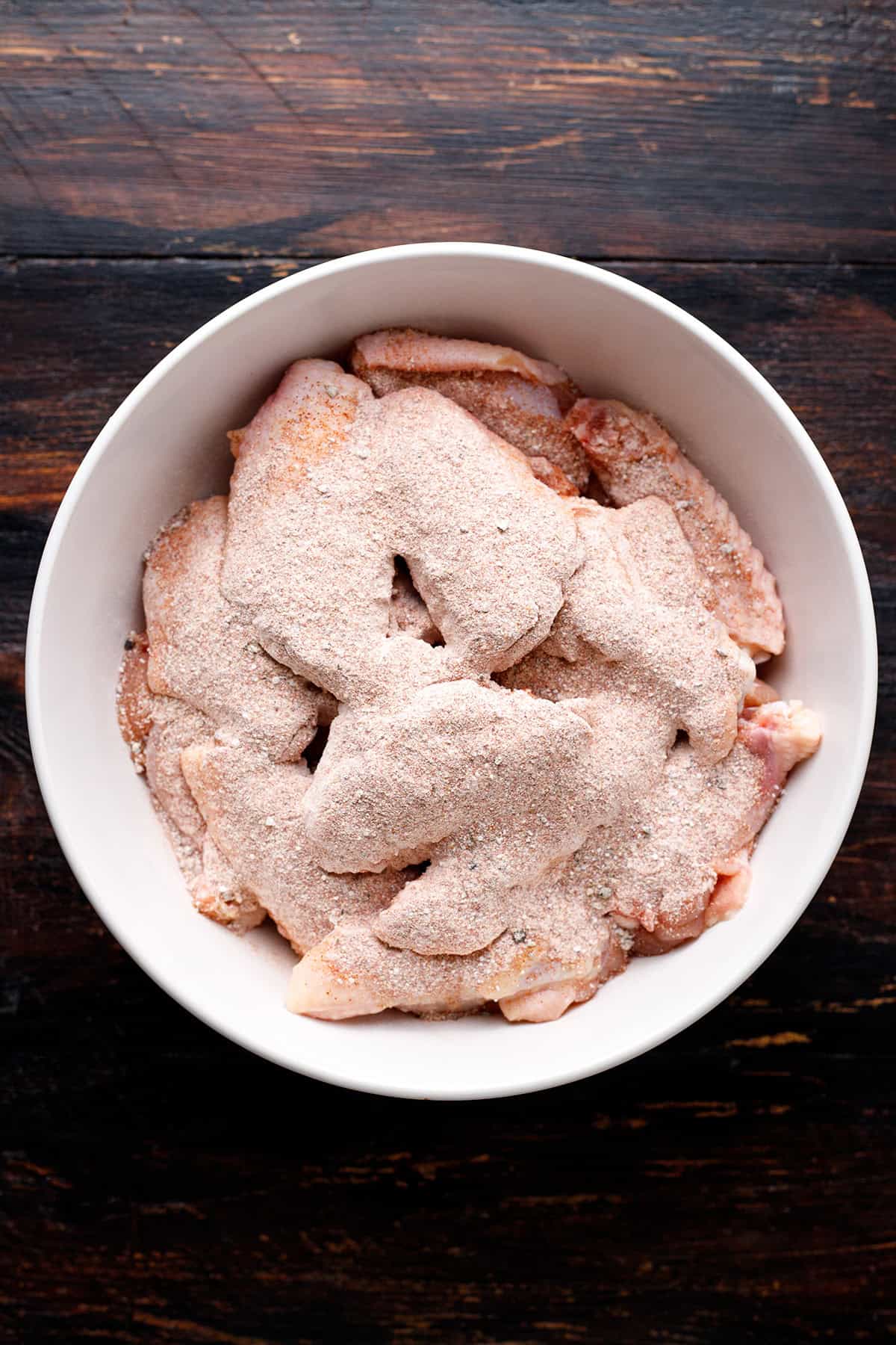 chicken wings coated in spices - in a bowl.
