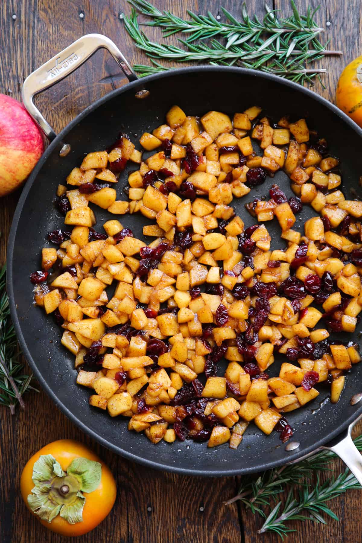 Cooked apples and cranberries in a skillet.