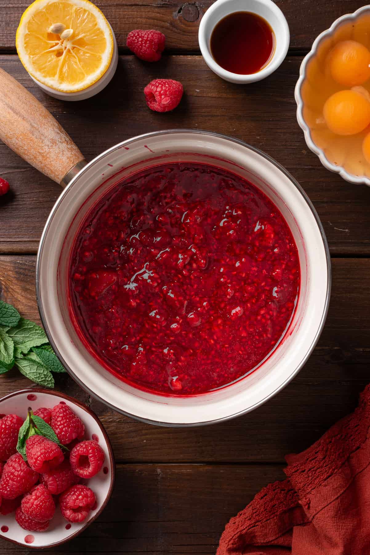 Cooked raspberries in a small pot.