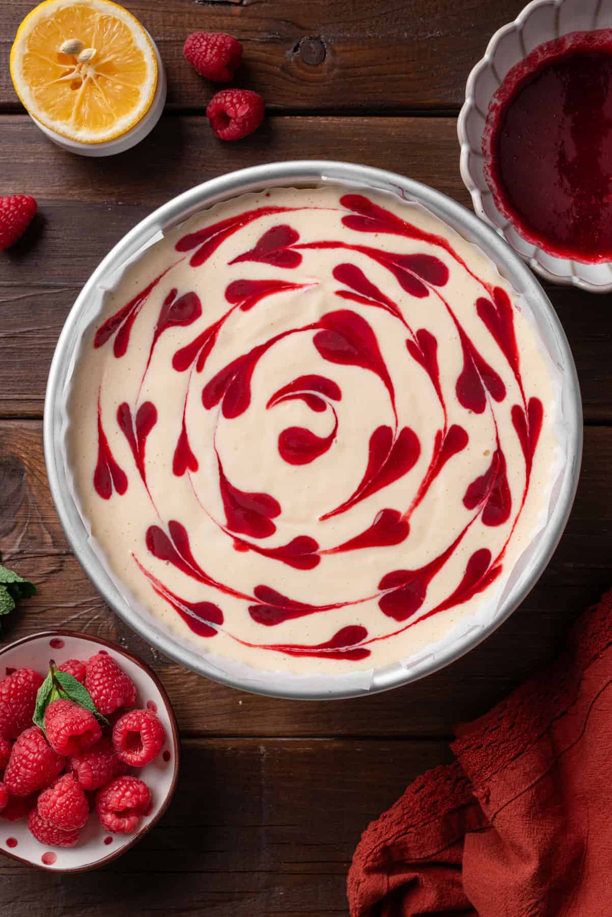 Make raspberry puree swirl over the cheesecake mixture in a baking pan.