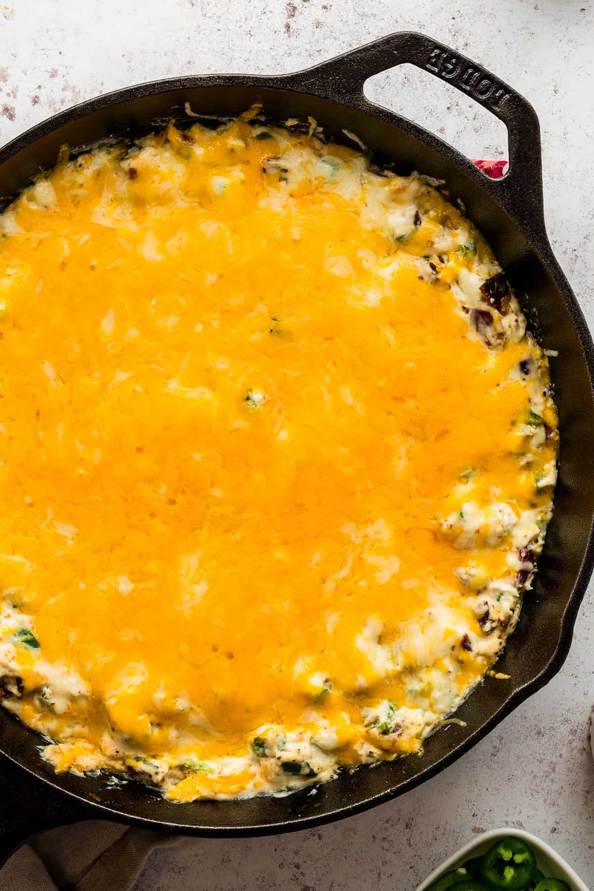 melted cheddar on top of the jalapeno popper dip in a cast iron skillet.