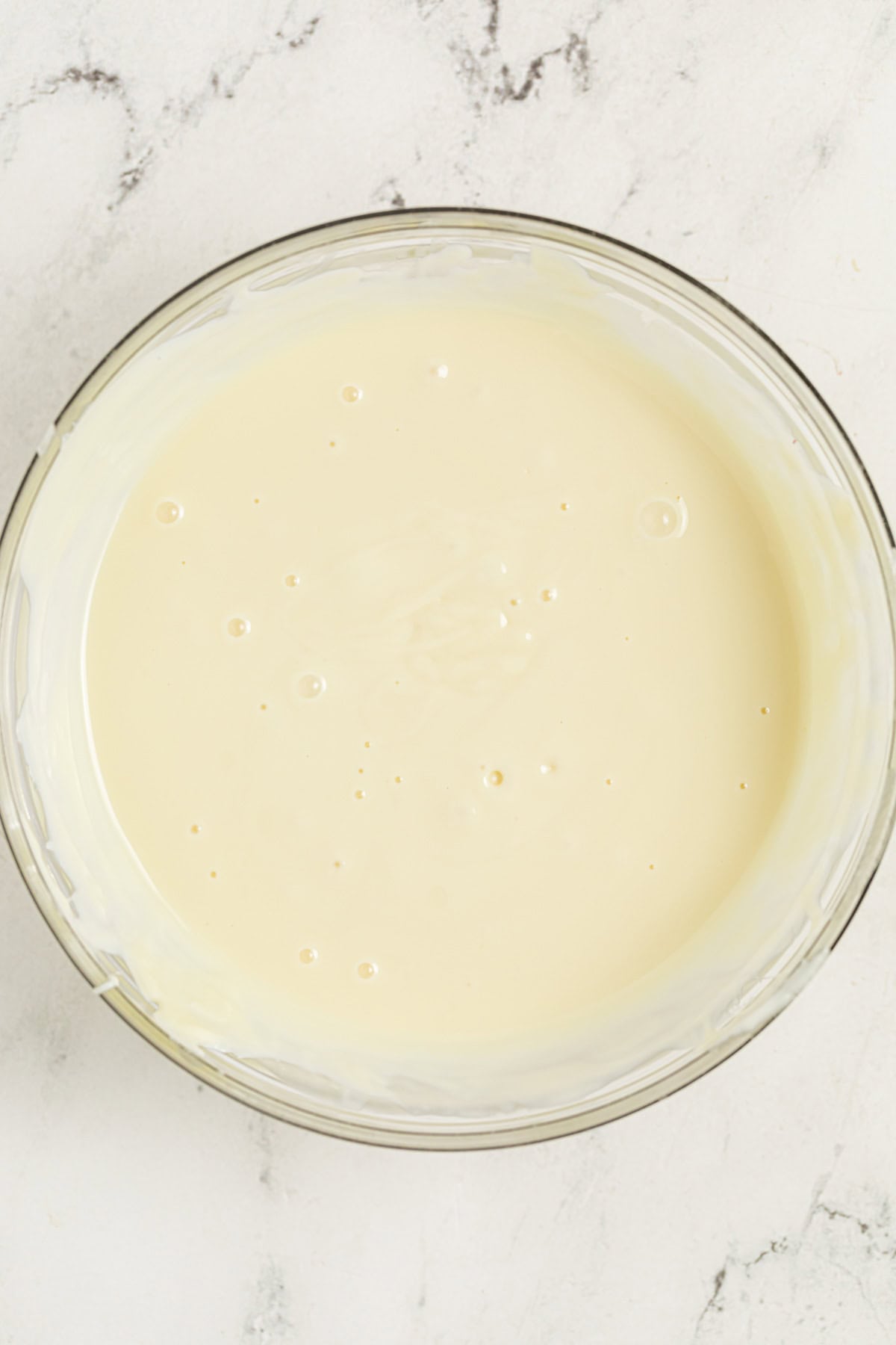 Melted white chocolate with coconut oil in a mixing bowl.