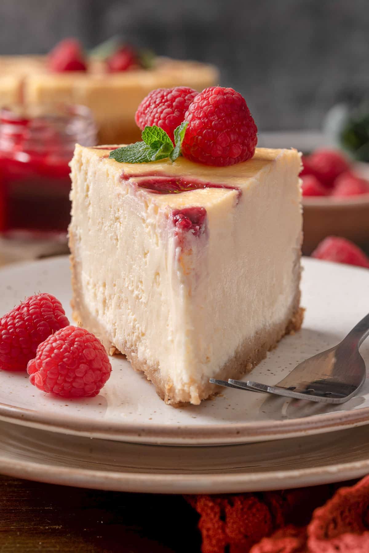 a slice of raspberry cheesecake - on a plate.