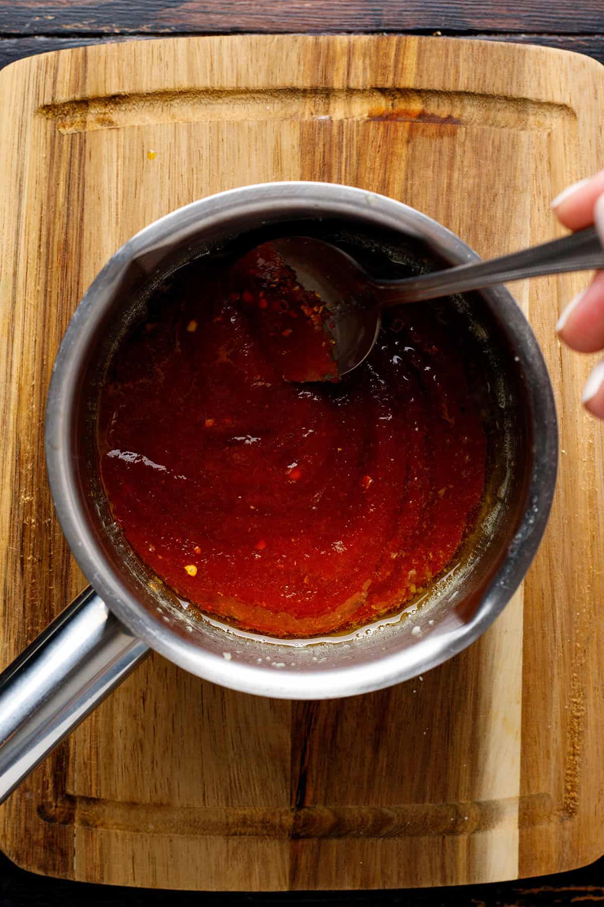 add sriracha sauce, honey, chili flakes, and salt to the melted butter and minced garlic in a small pot.