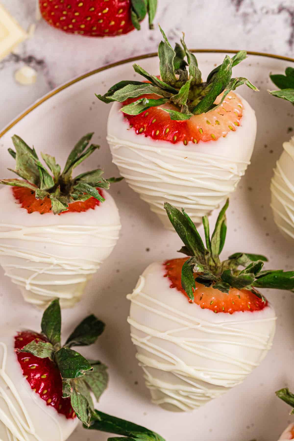 White chocolate covered strawberries - on a plate.