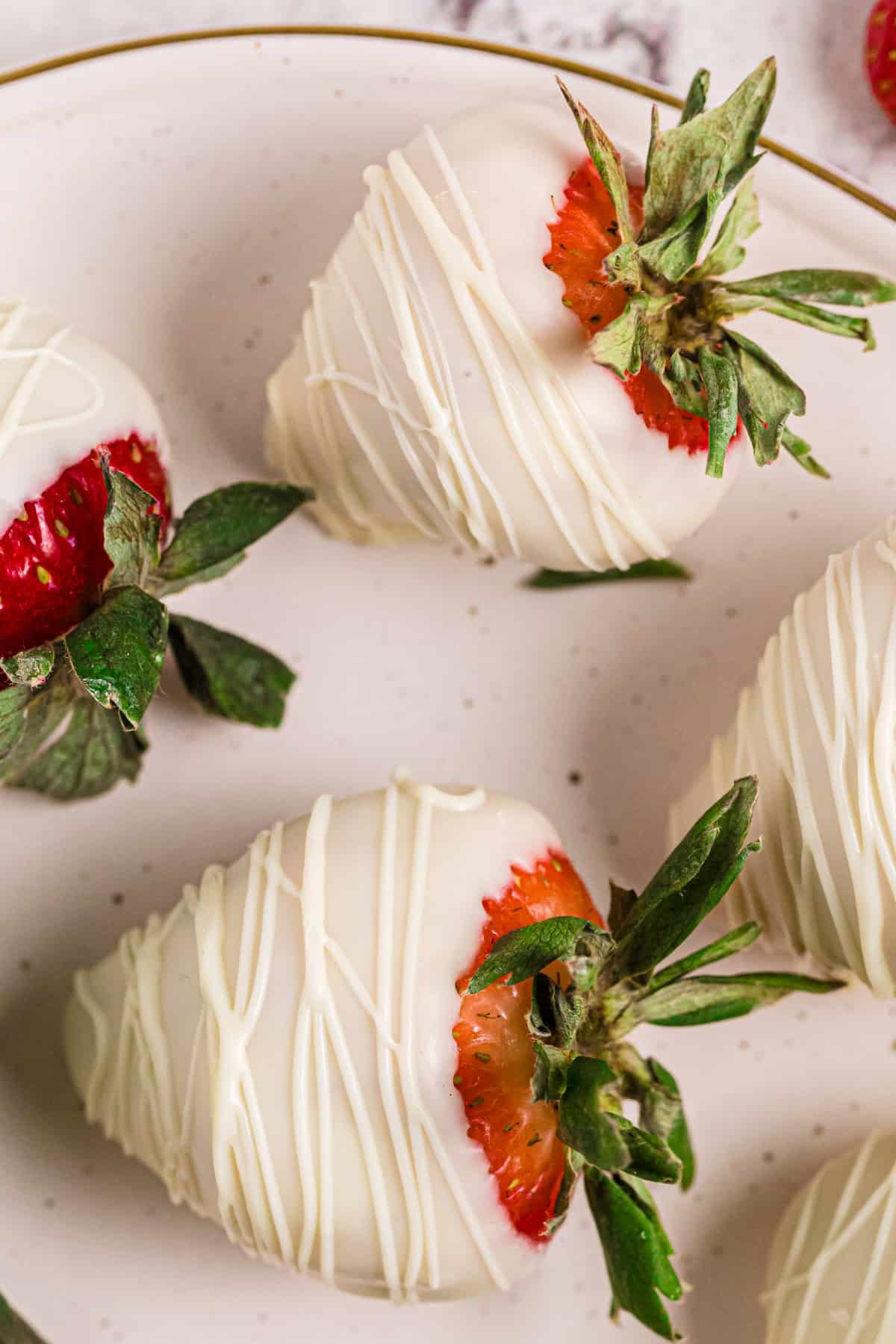White chocolate covered strawberries - on a plate.