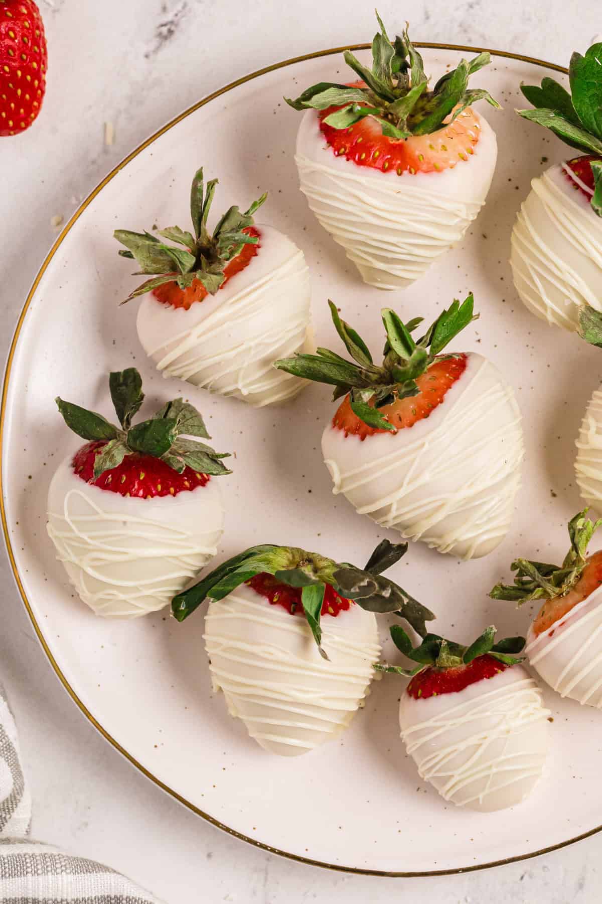 White chocolate covered strawberries - on a plate.