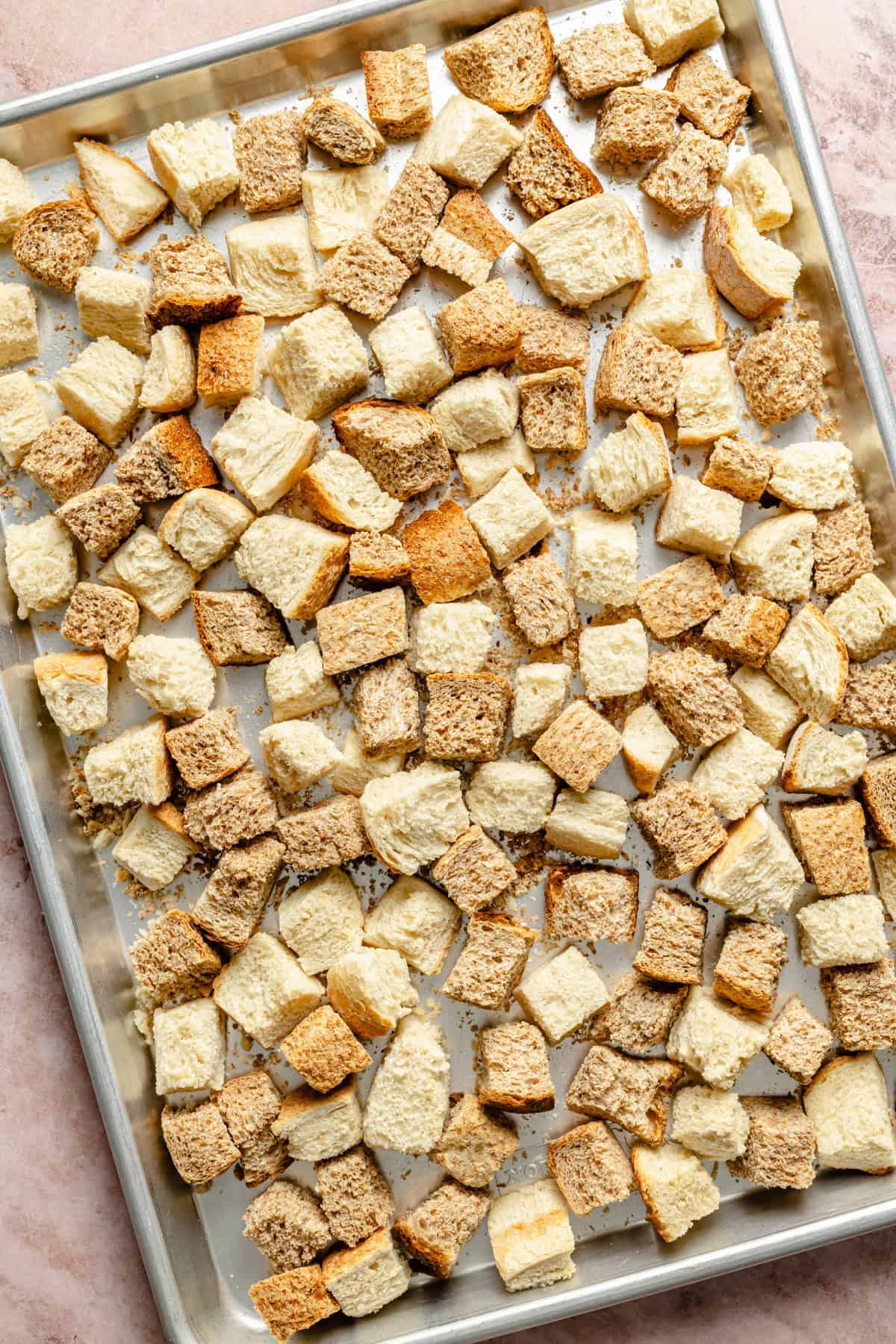 bread cubes drying out on a sheet pan for stuffing.