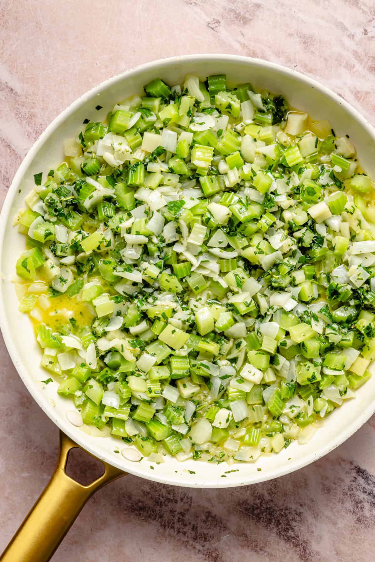 sauteeing onion, celery, and herbs in a saucepan with butter.