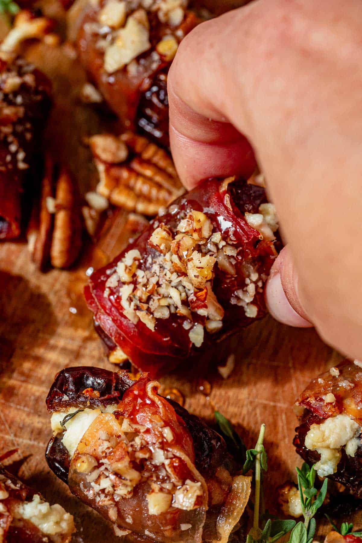 picking up a prosciutto wrapped date form a serving platter.