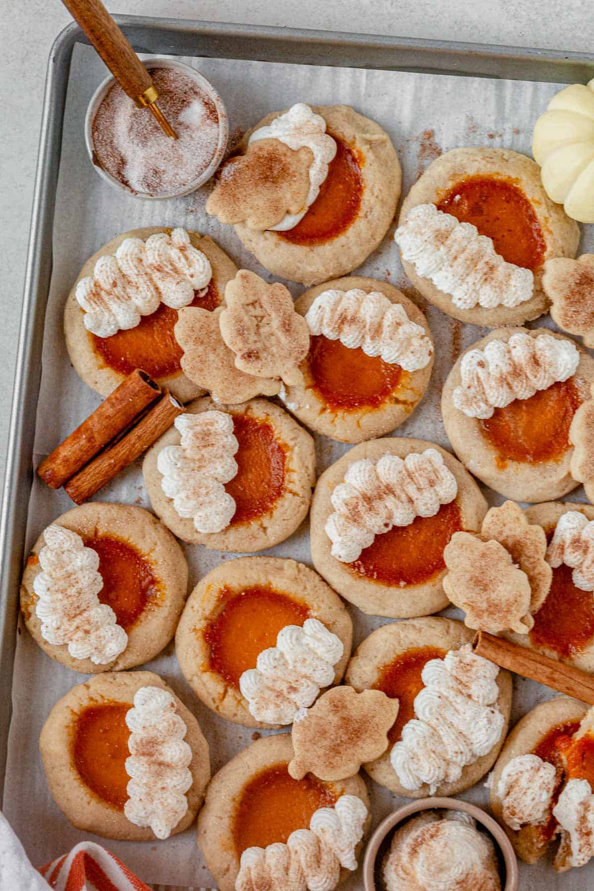 a tray of pumpkin pie cookies topped with whipped cream and cinnamon.