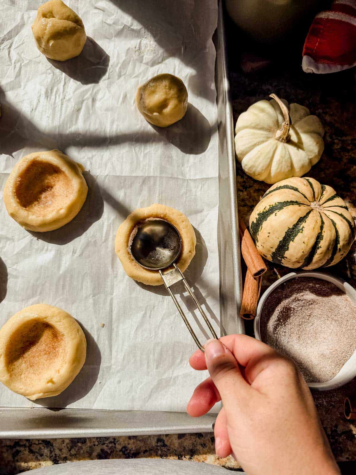 pressing the back of a spoon into cookie dough to make a well in the center.