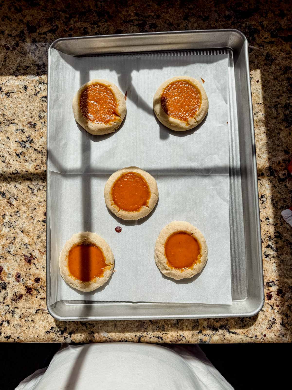 baked pumpkin pie cookies cooling on a baking sheet.